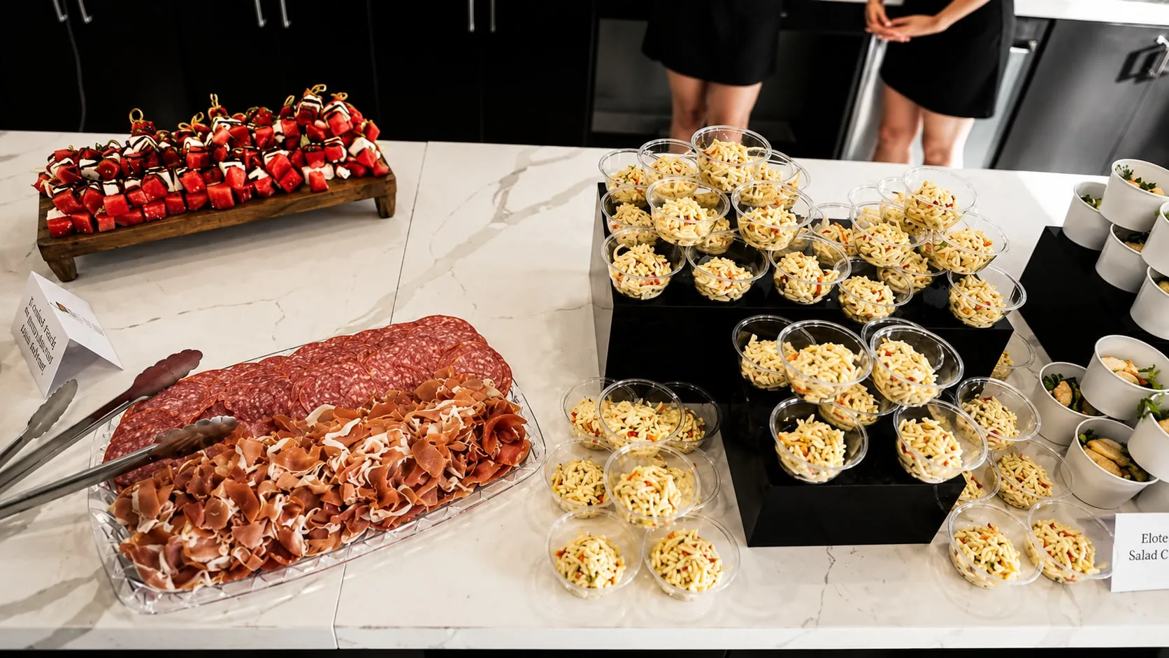 A charcuterie platter with passed bites on white risers
